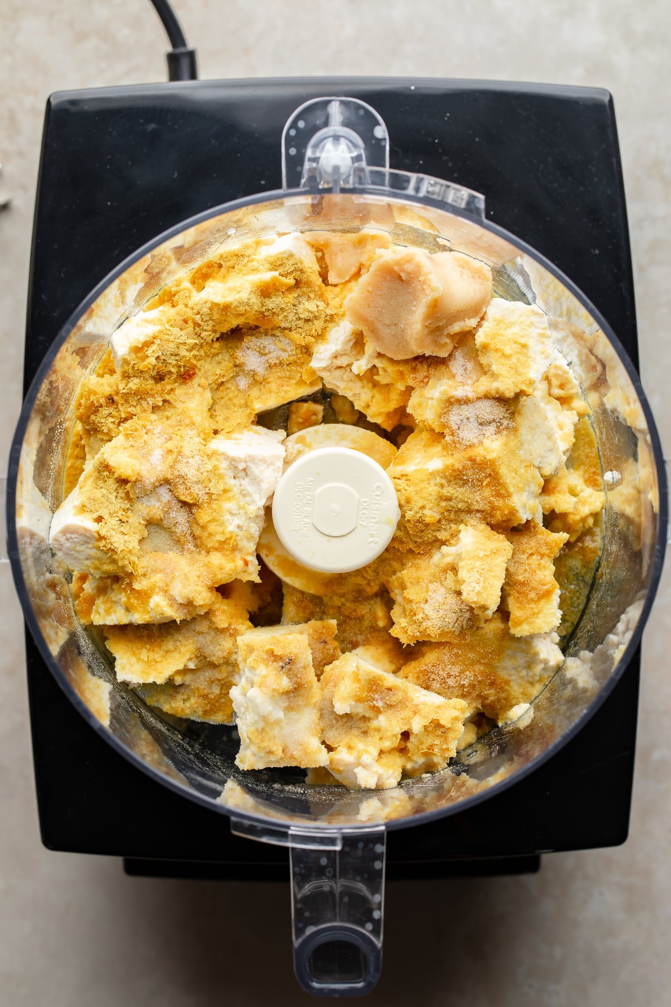overhead view of the ingredients for whipped tofu ricotta in a food processor.