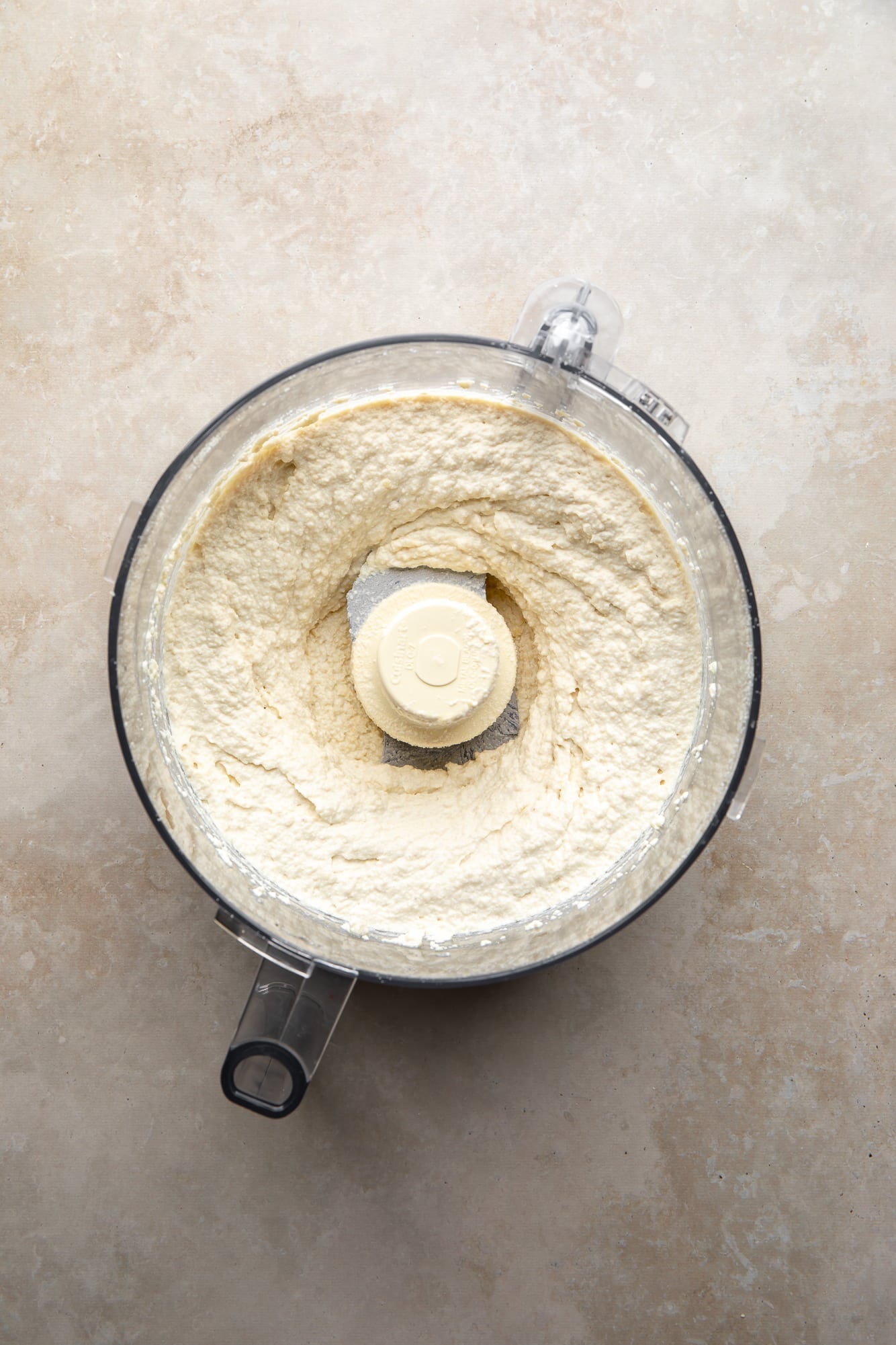 overhead view of white vegan ricotta for vegan white lasagna in a food processor.