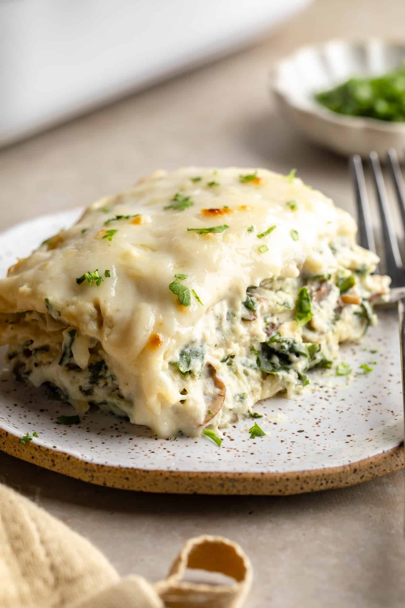 close up on a slice of vegan white lasagna on a plate.