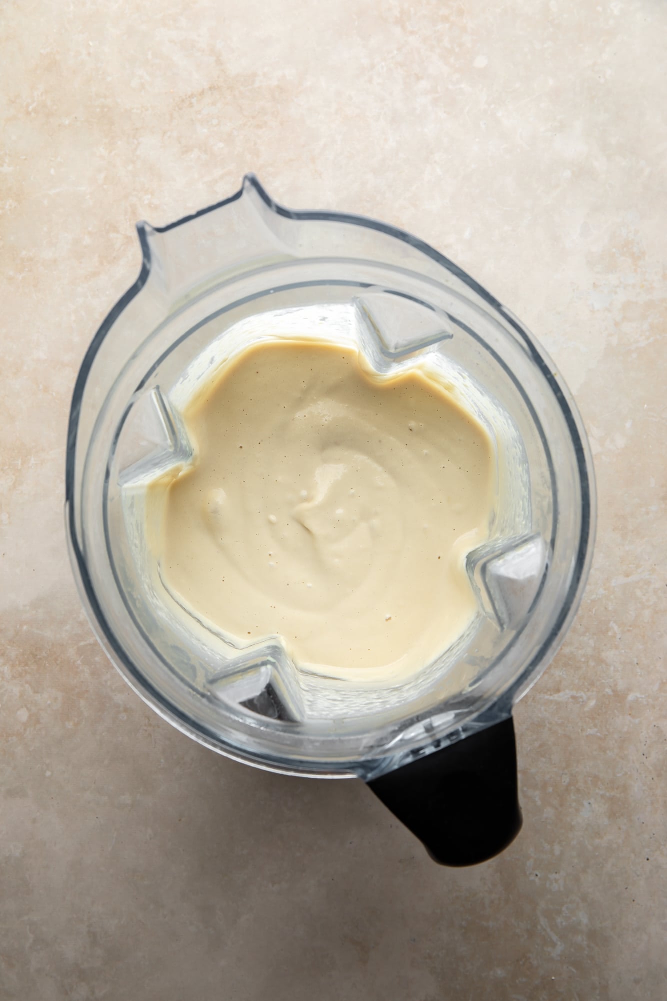 overhead view of white vegan alfredo sauce for vegan white lasagna in a blender.