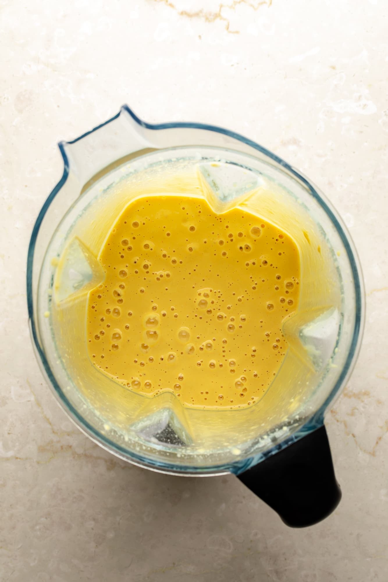 overhead view of blended golden yum sauce in a blender.