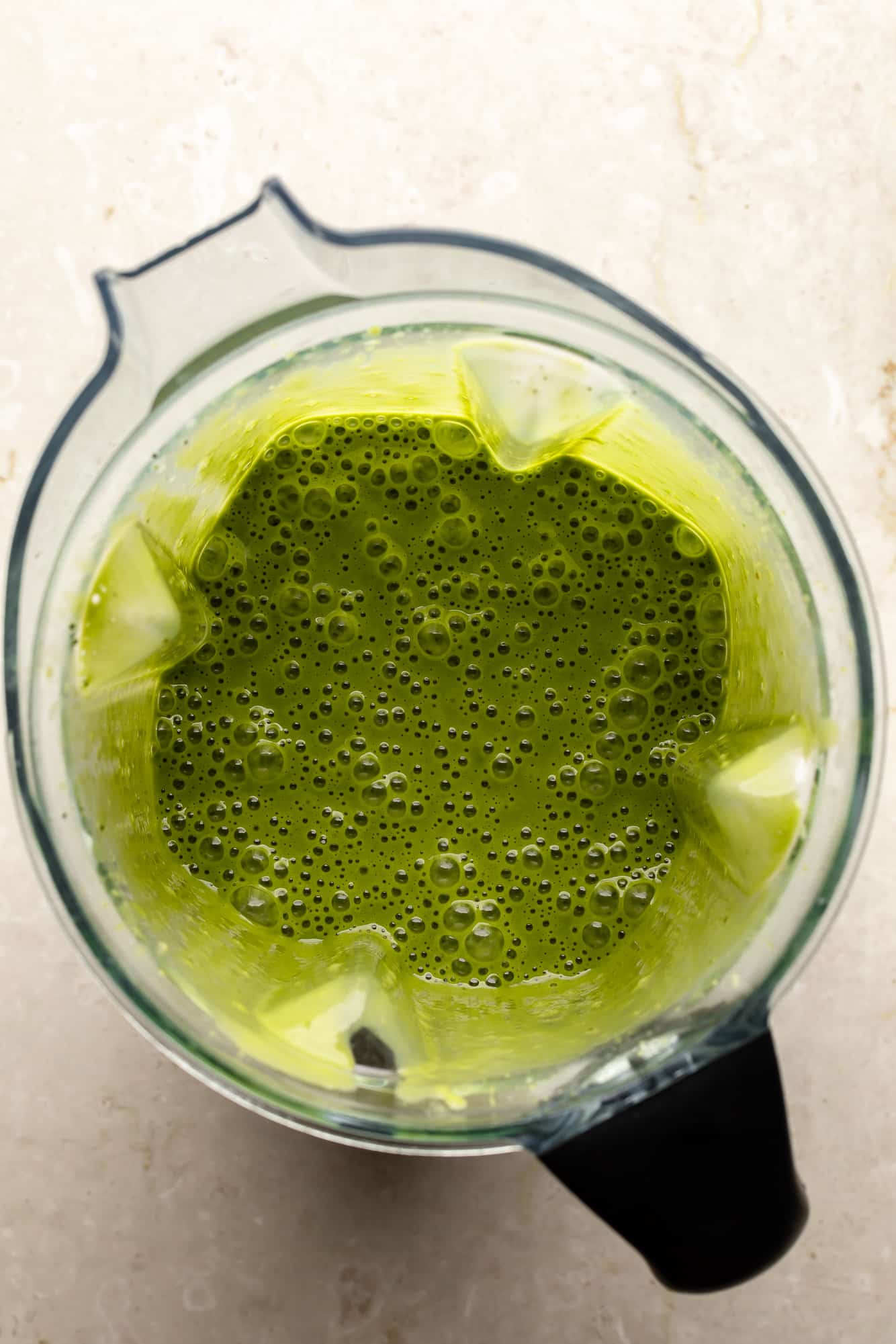 overhead view of a matcha smoothie in a large blender.