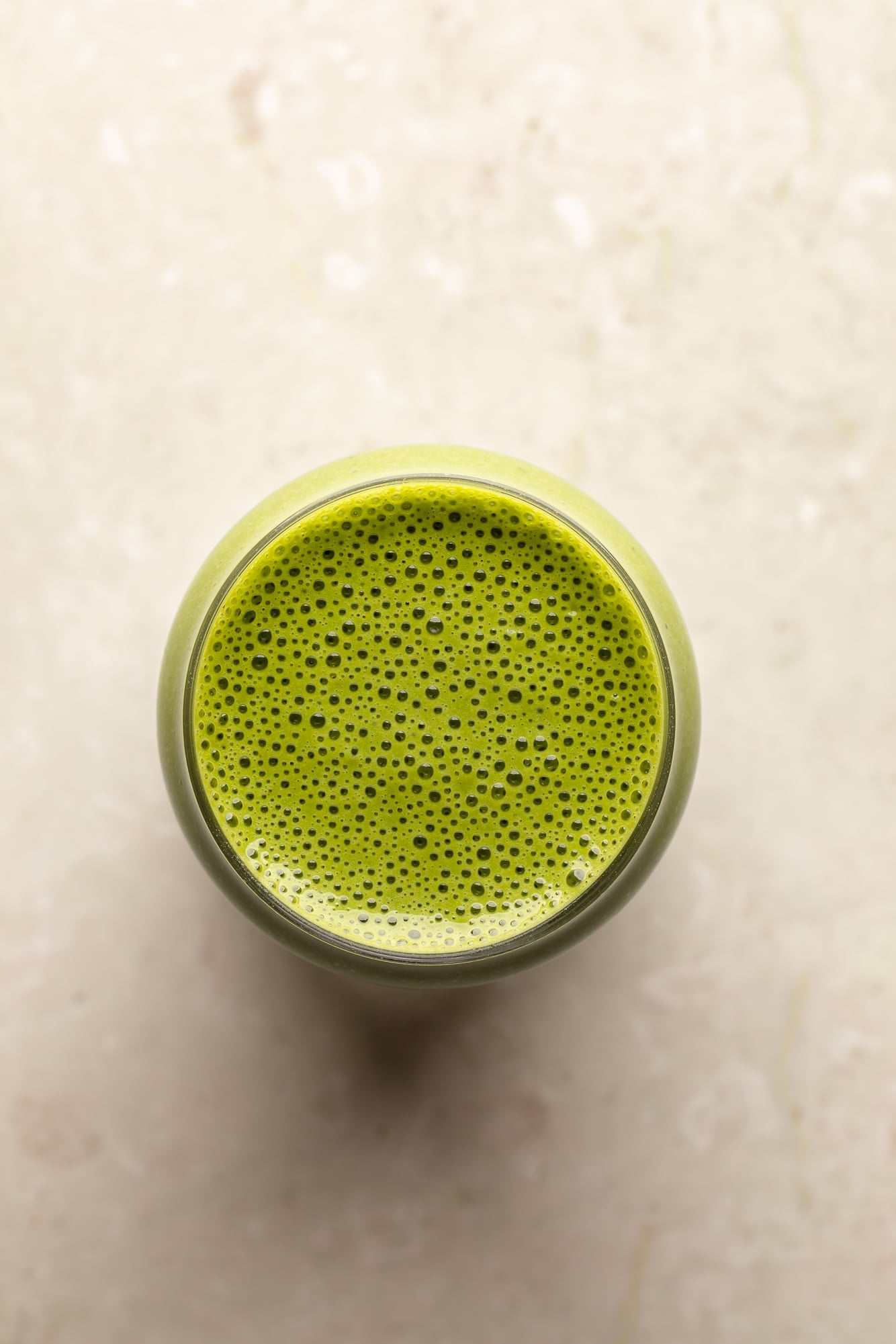 overhead view of a matcha smoothie in a glass.