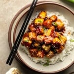 overhead view of sesame tofu on top of rice in a bowl.