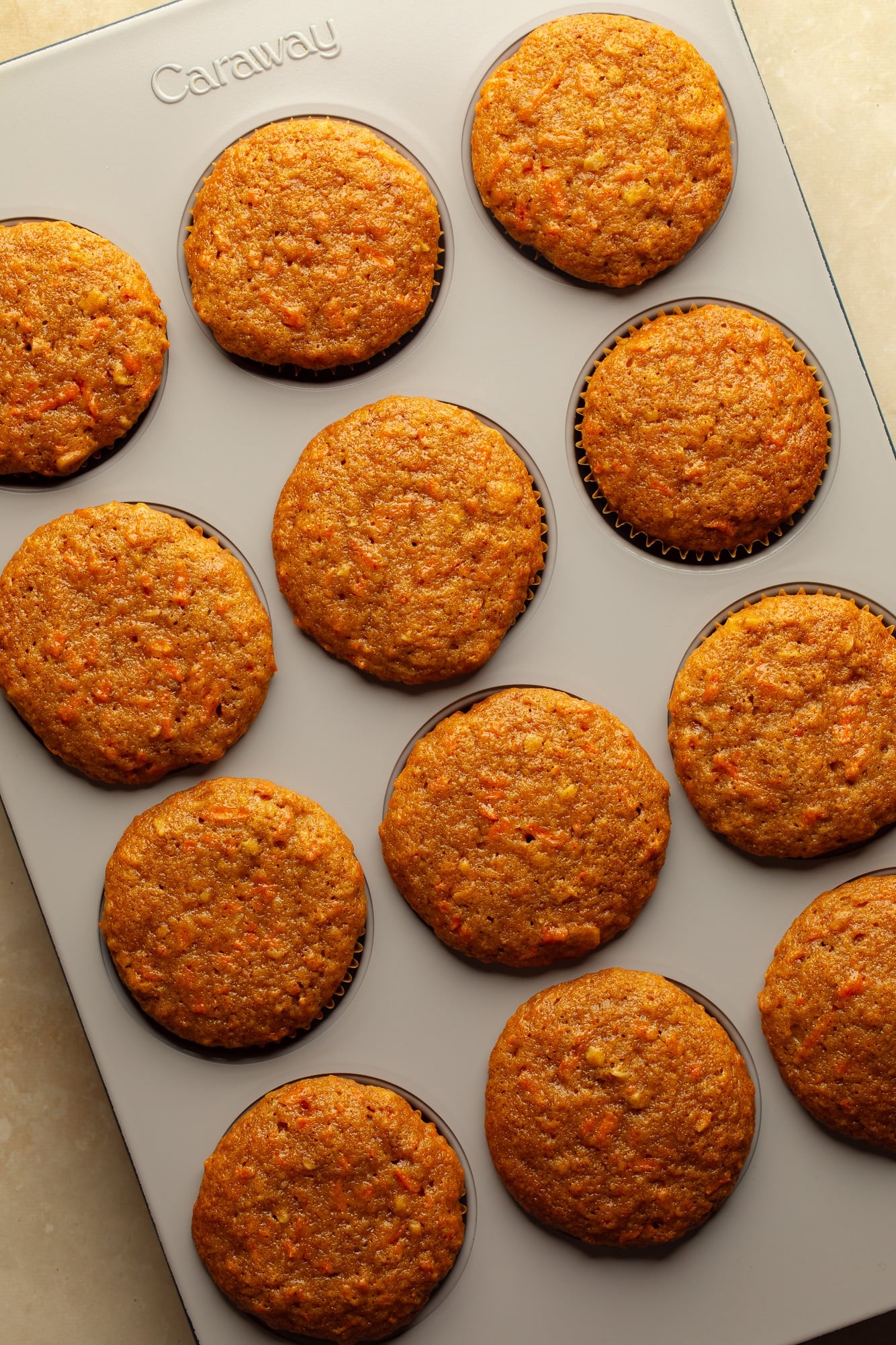 overhead view of baked vegan carrot cake cupcakes in a muffin tin.