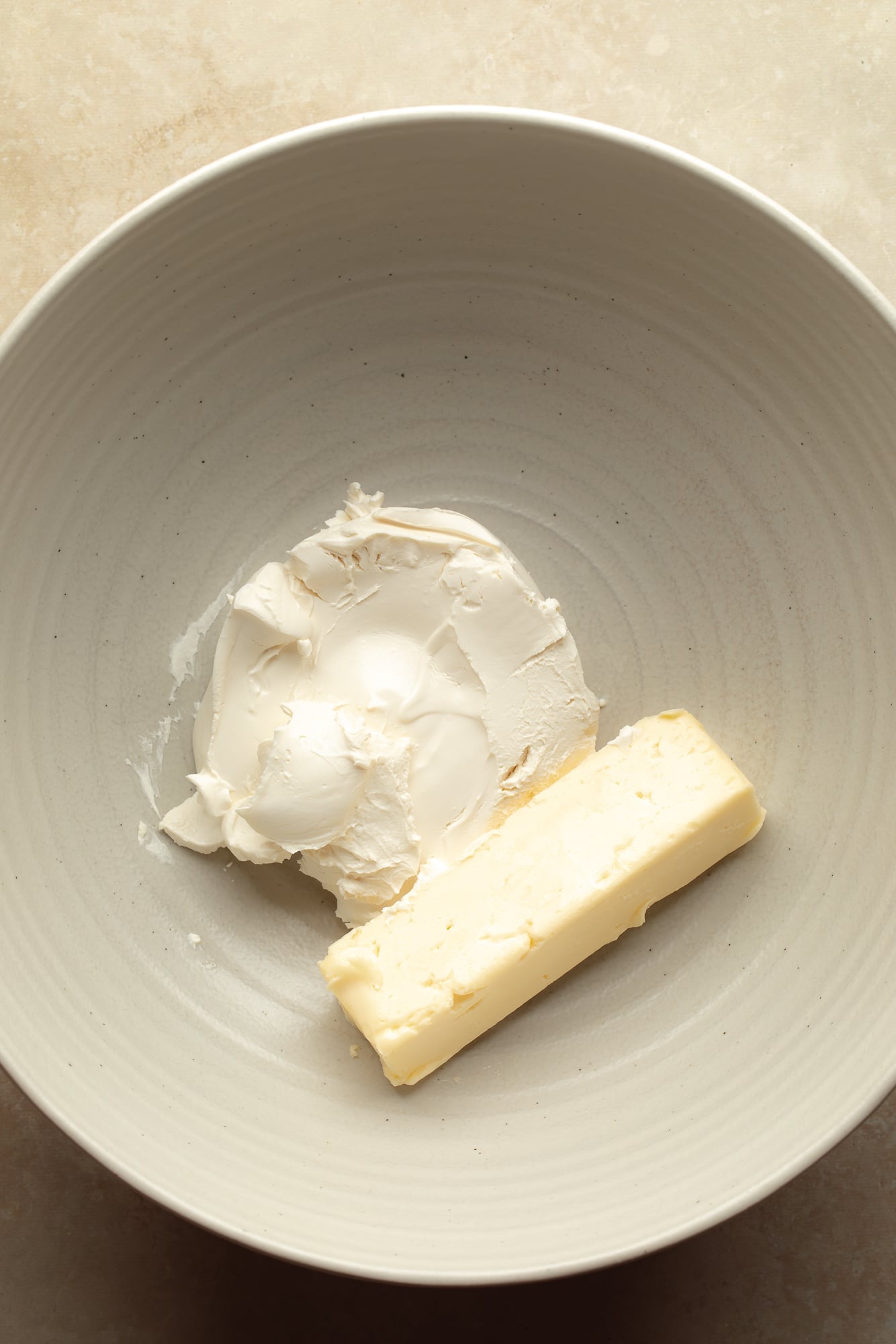 overhead view of a vegan butter and vegan cream cheese in a large bowl.