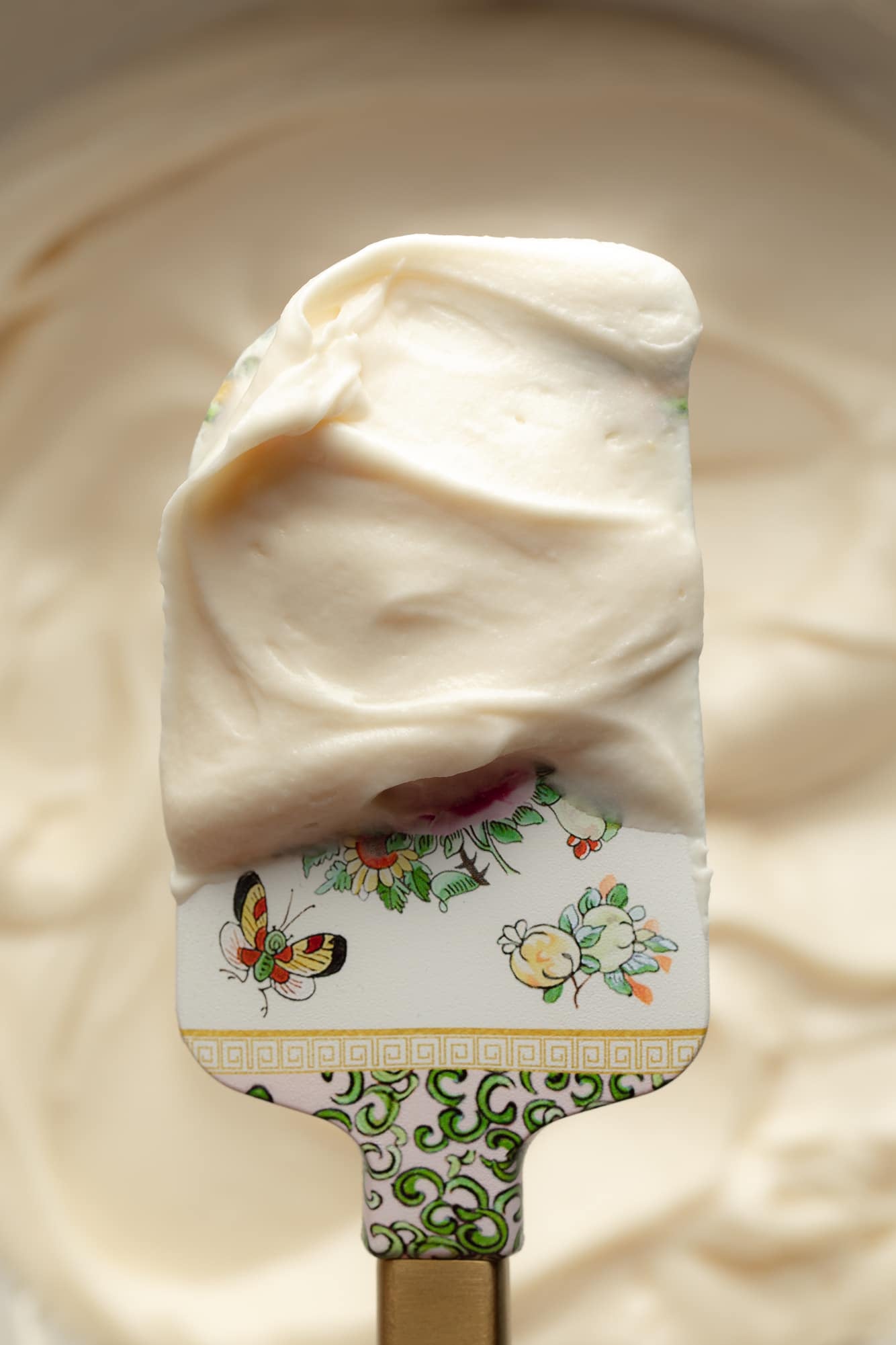 close up on a spatula covered in vegan cream cheese frosting.