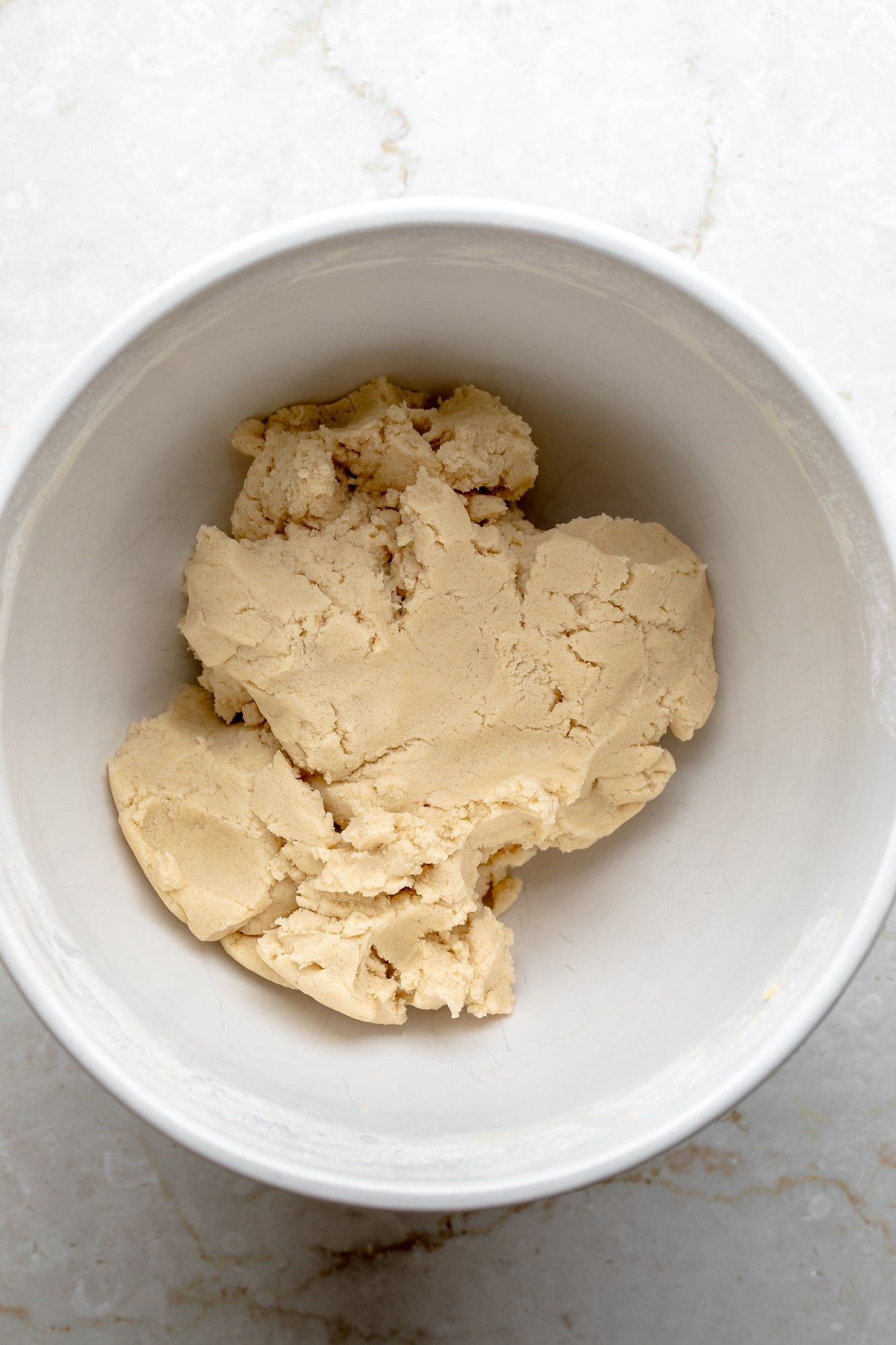 overhead view of raw shortbread cookie dough in a white bowl.