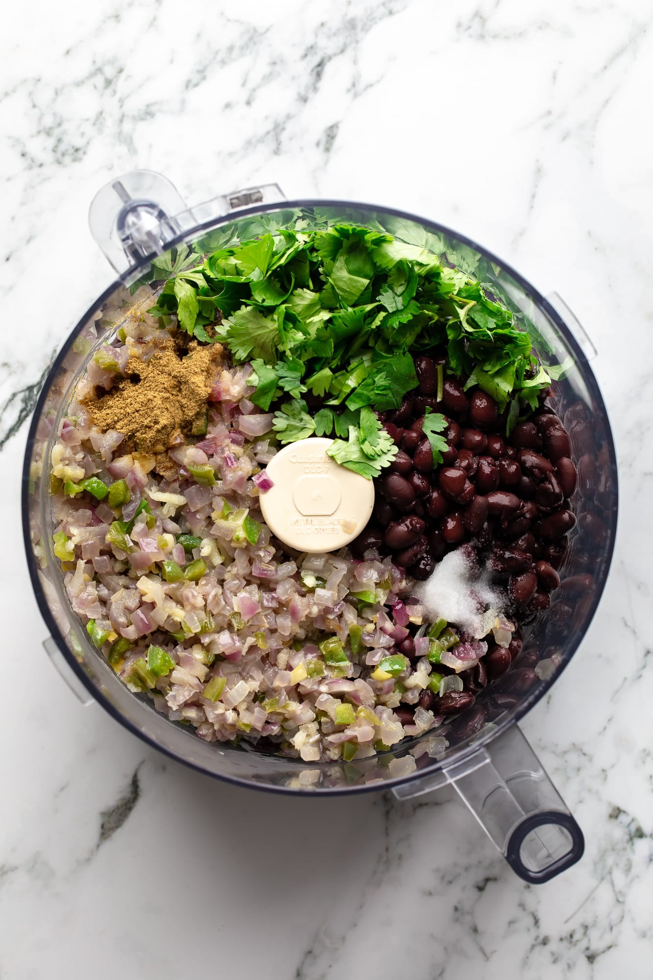 overhead view of the ingredients for black bean dip in a food processor.