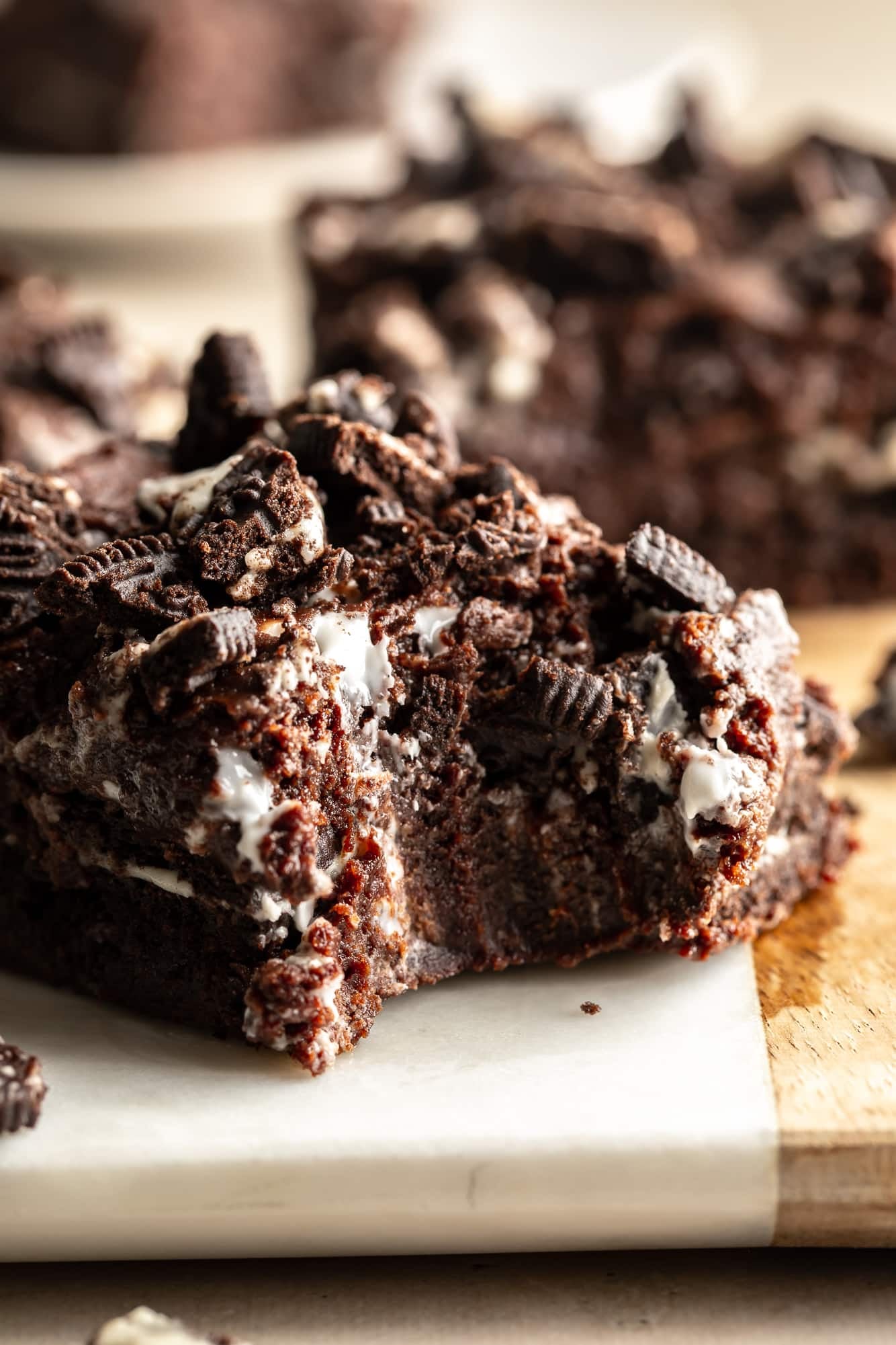 close up on a vegan cookies and cream brownie with a bite taken out of it.