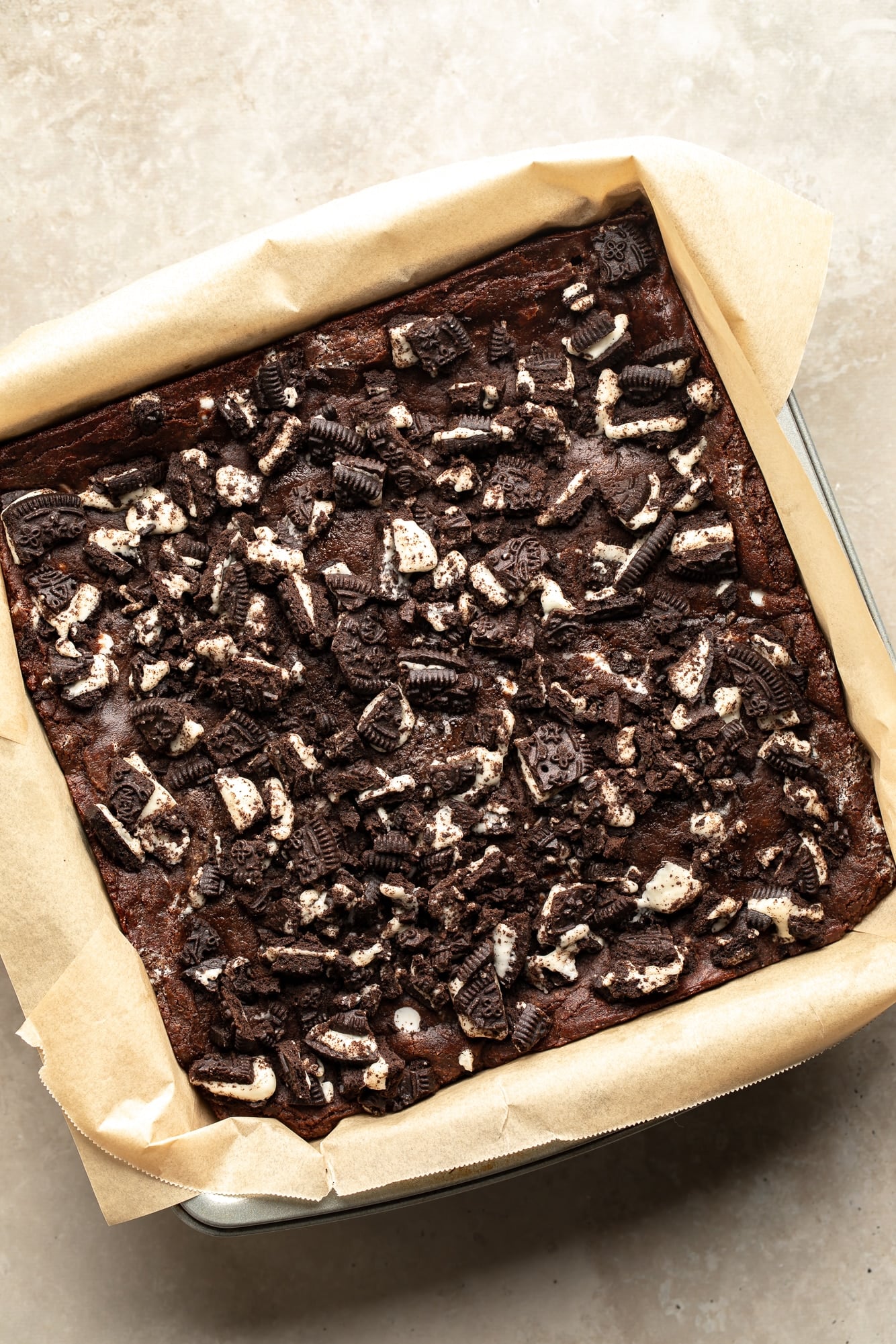 overhead view of baked cookies and cream brownies in a baking pan.