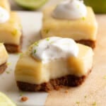 Side view of a vegan key lime pie bar topped with vegan whipped cream with a bite taken out of it.