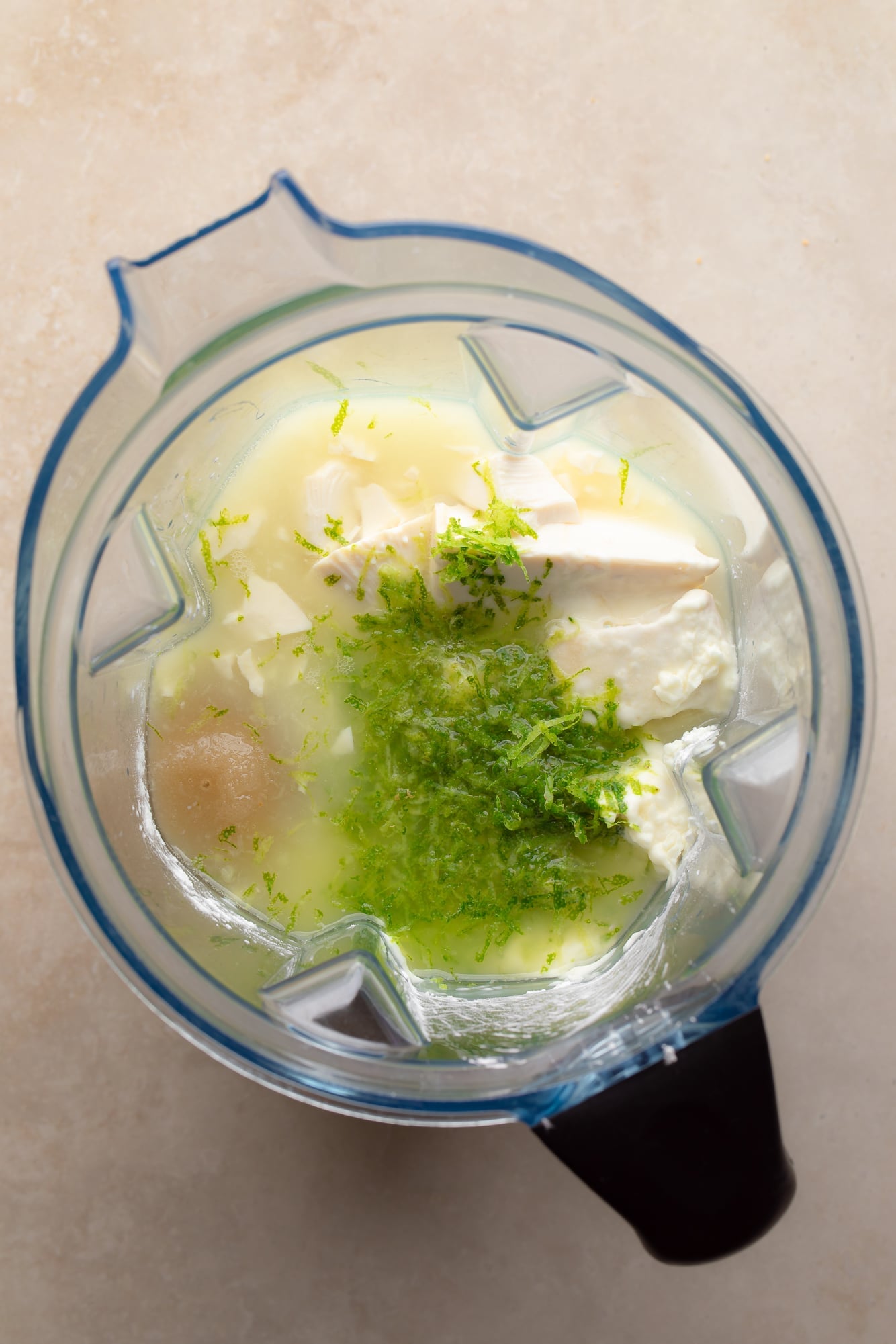 Overhead view of the ingredients for a vegan key lime pie bars in a blender.