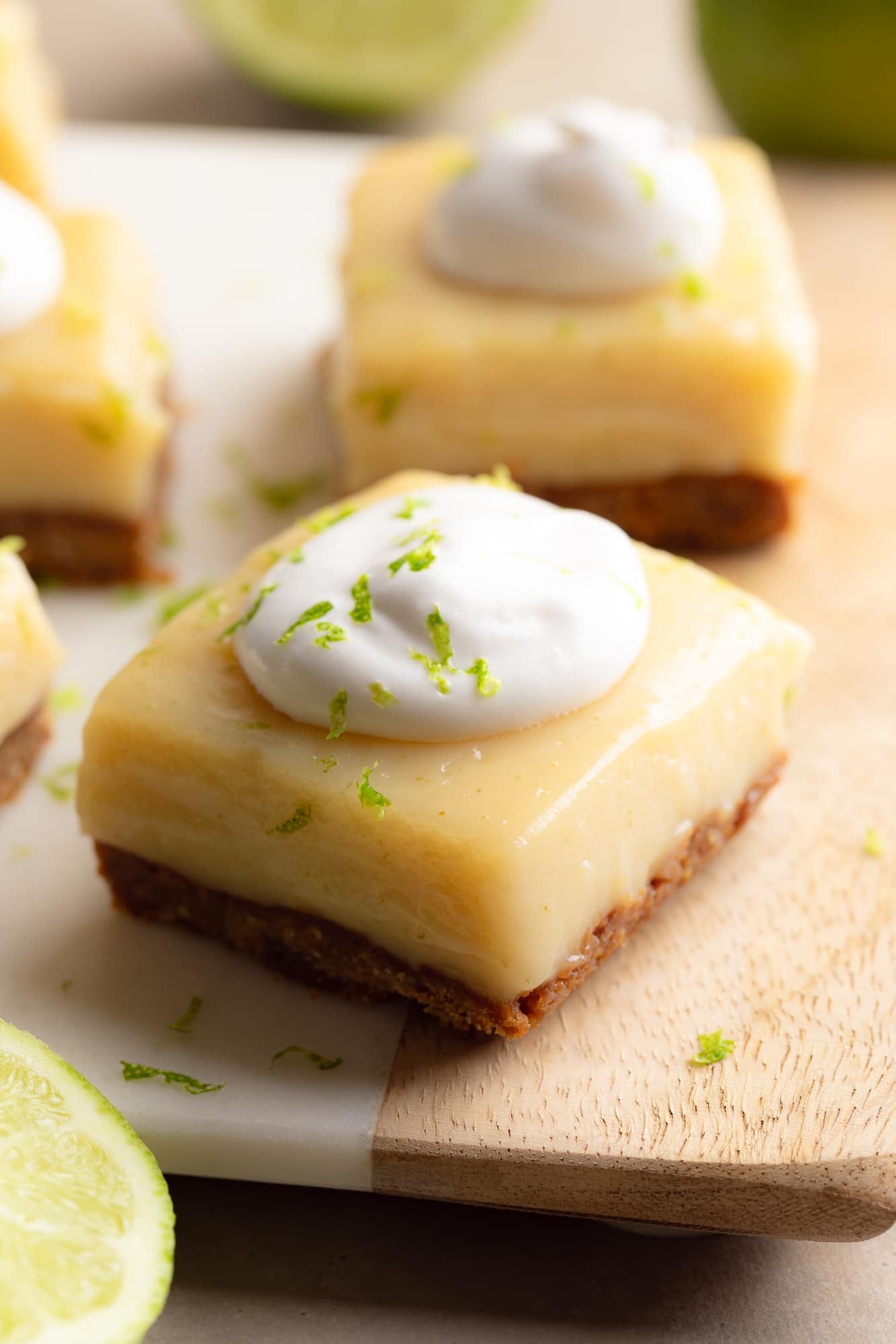 Side view of a vegan key lime pie bar topped with vegan whipped cream.