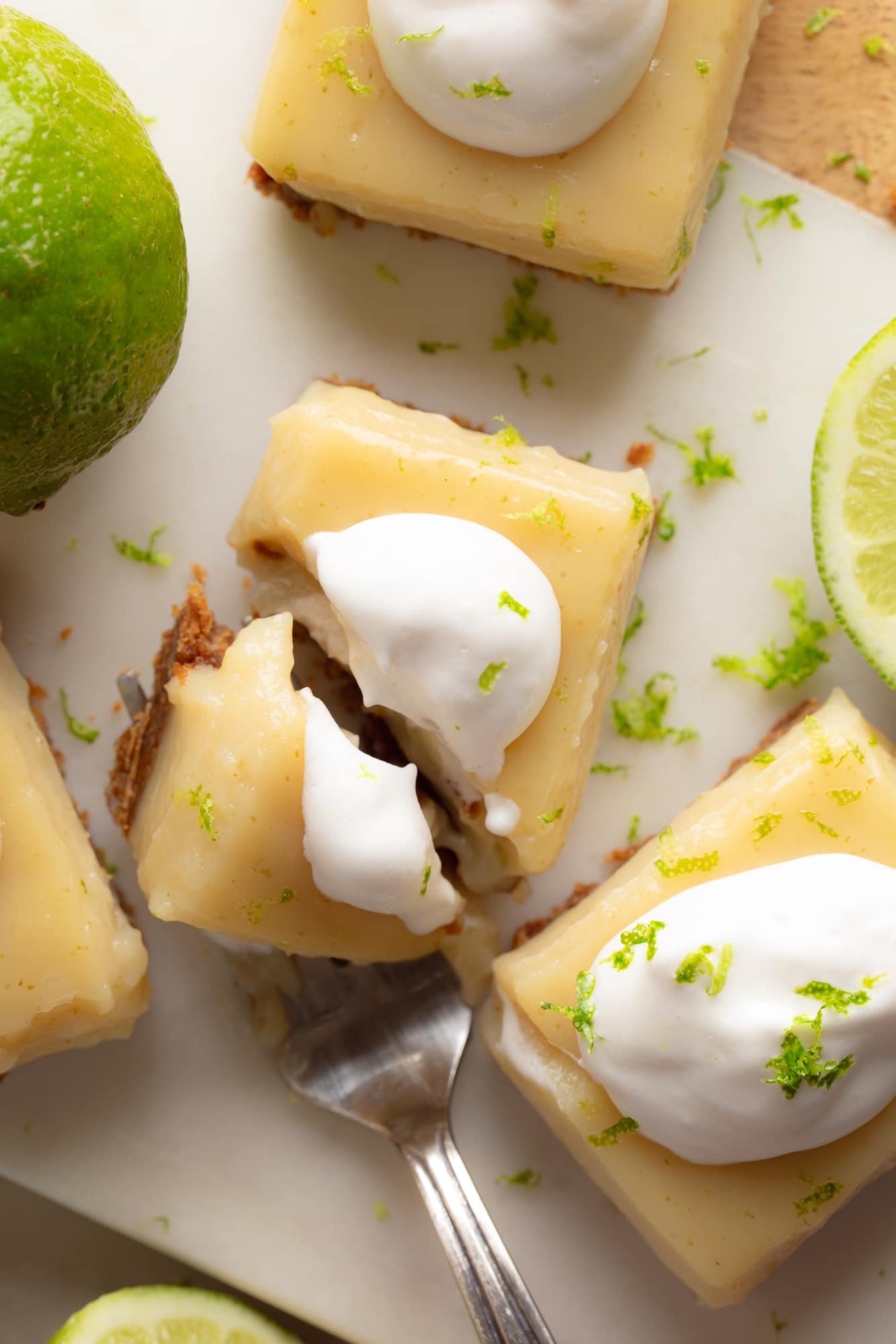 Overhead view of a fork cutting into a vegan key lime pie bar.