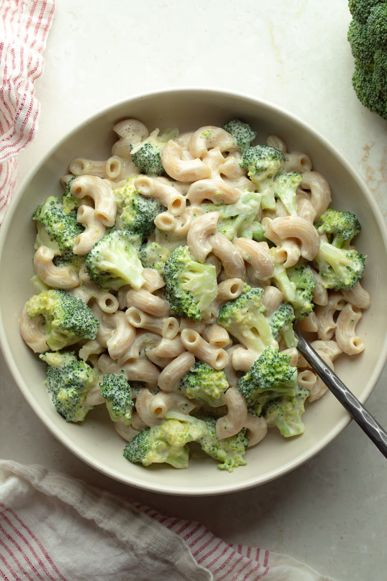 overhead view of vegan white mac and cheese with broccoli in a bowl.