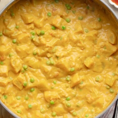 overhead view of vegan potato curry cooking in a large pot.