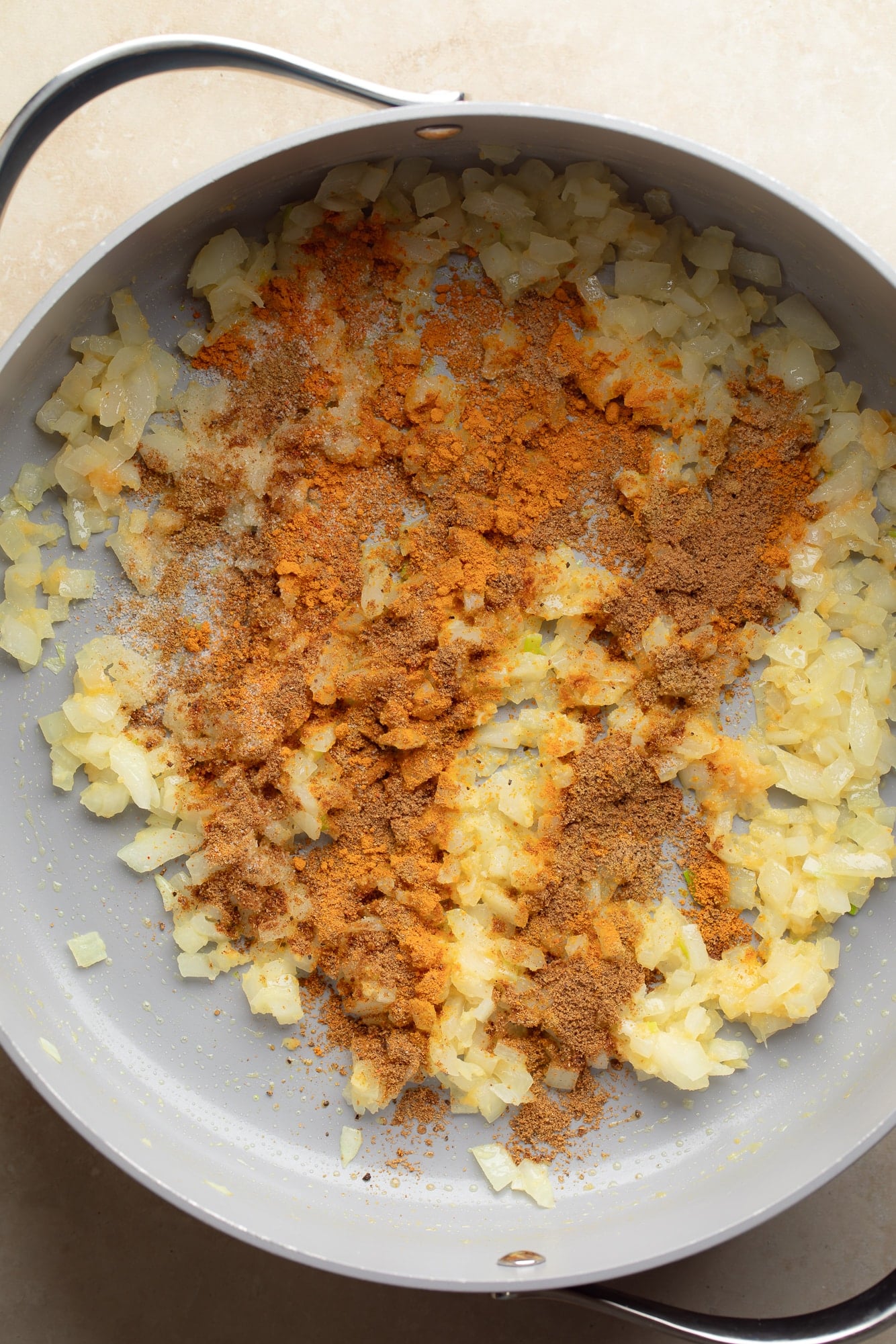 overhead view of cooked onions and spiced in a large pot.
