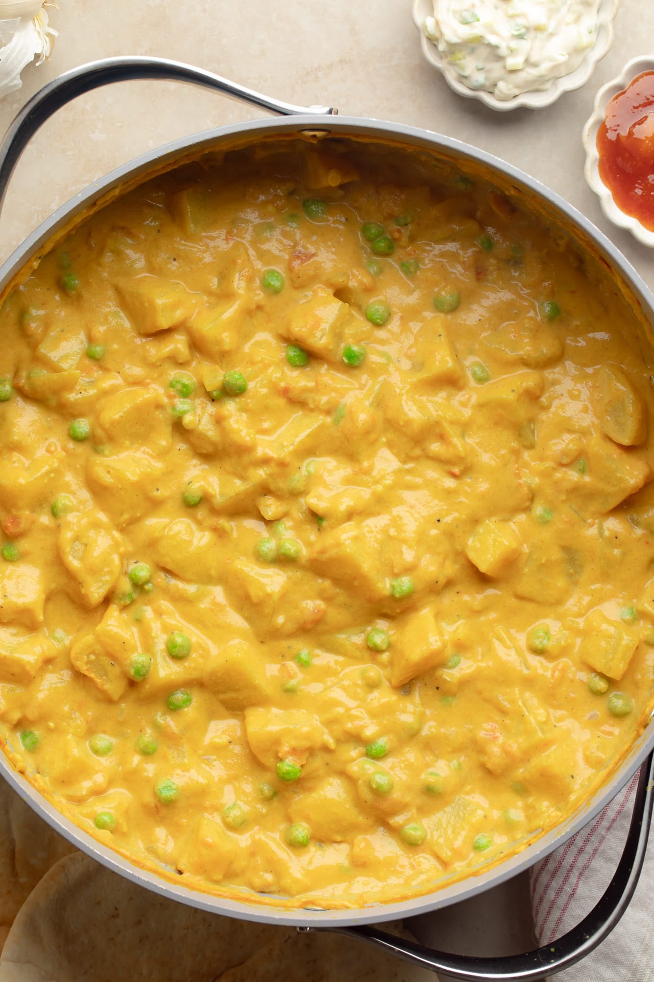 overhead view of vegan potato curry cooking in a large pot.