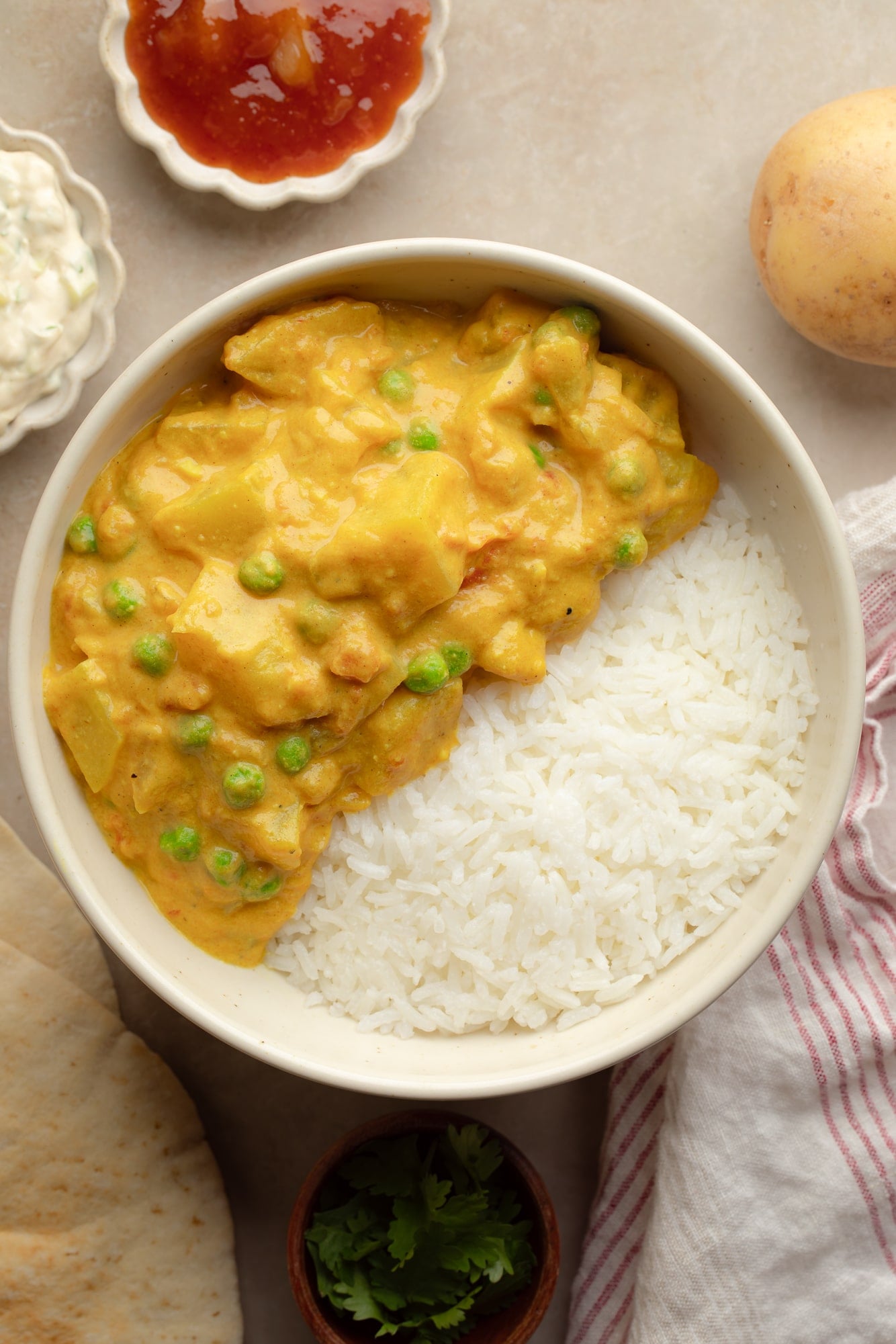 overhead view of a bowl of potato curry with rice.