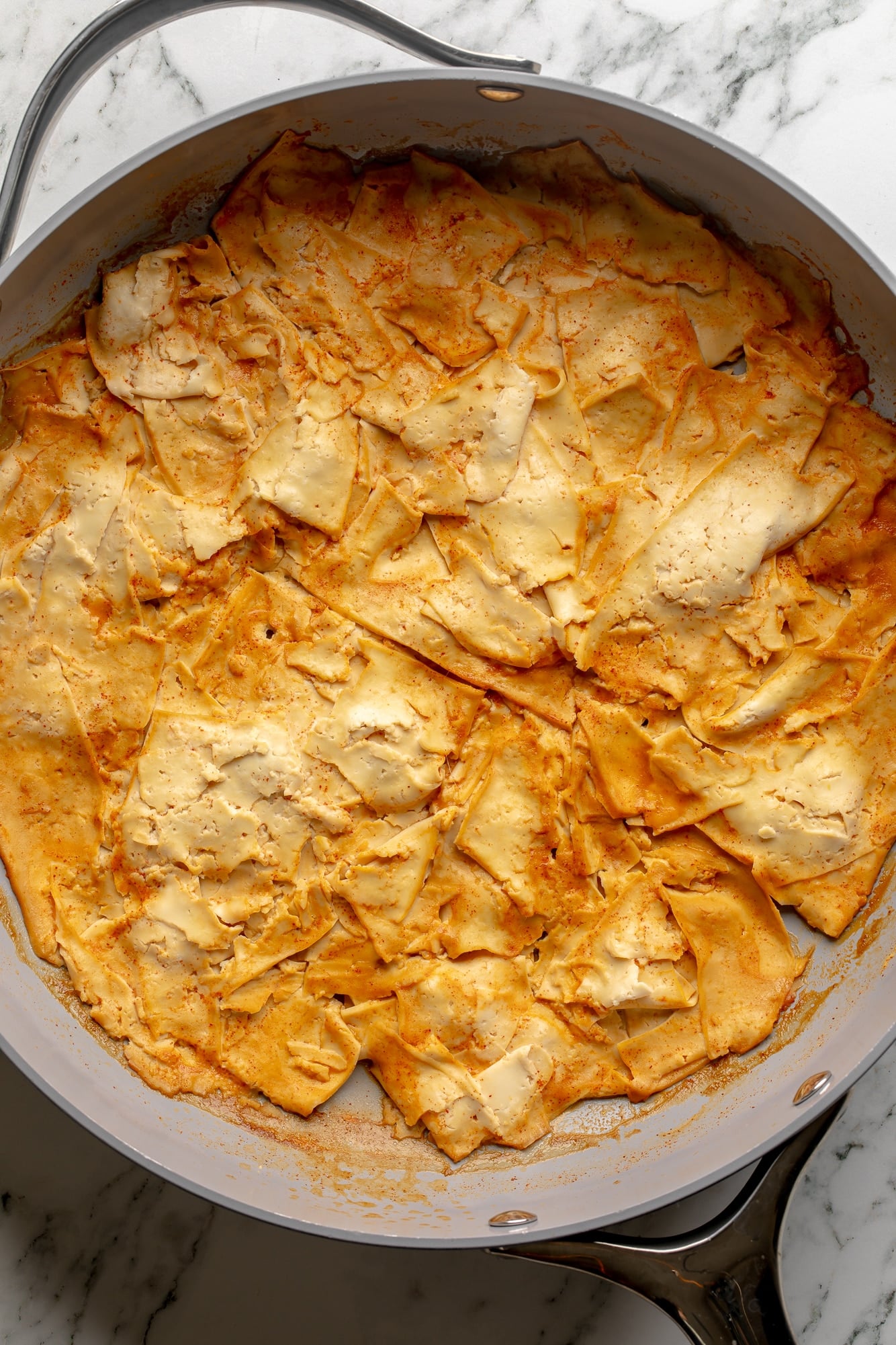 overhead view of cooked tofu slices in a large pan.
