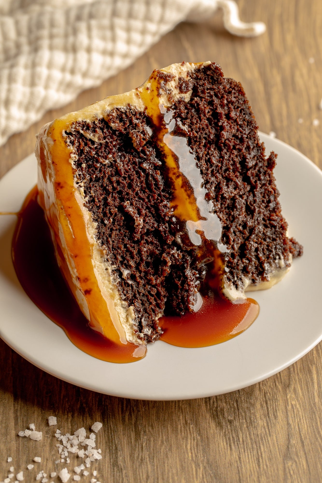 side view of a slice of vegan salted caramel chocolate cake.