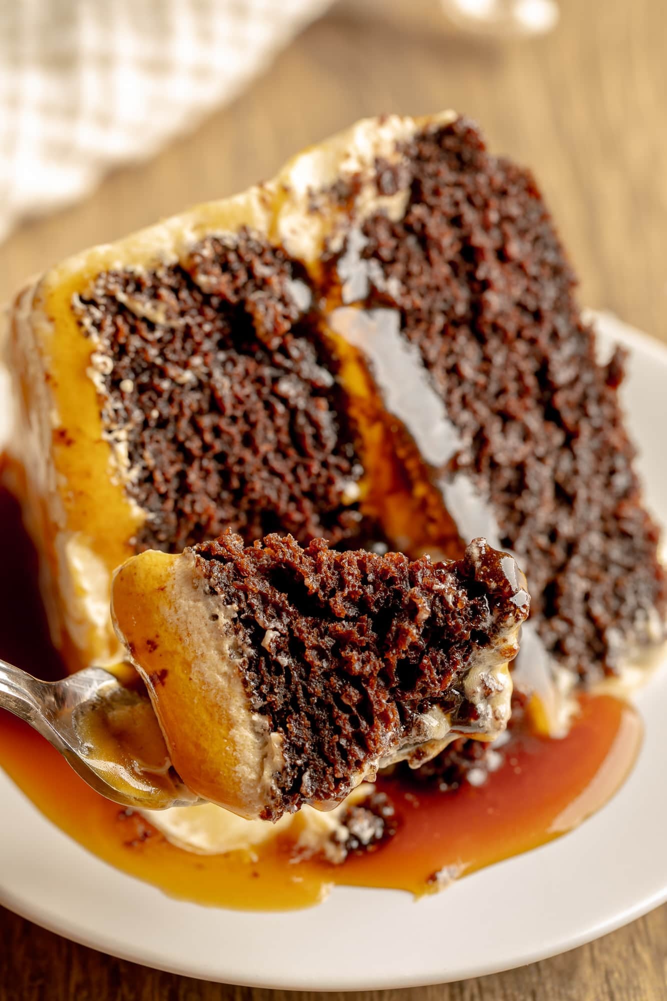 close up on a bite of vegan salted caramel chocolate cake on a fork.