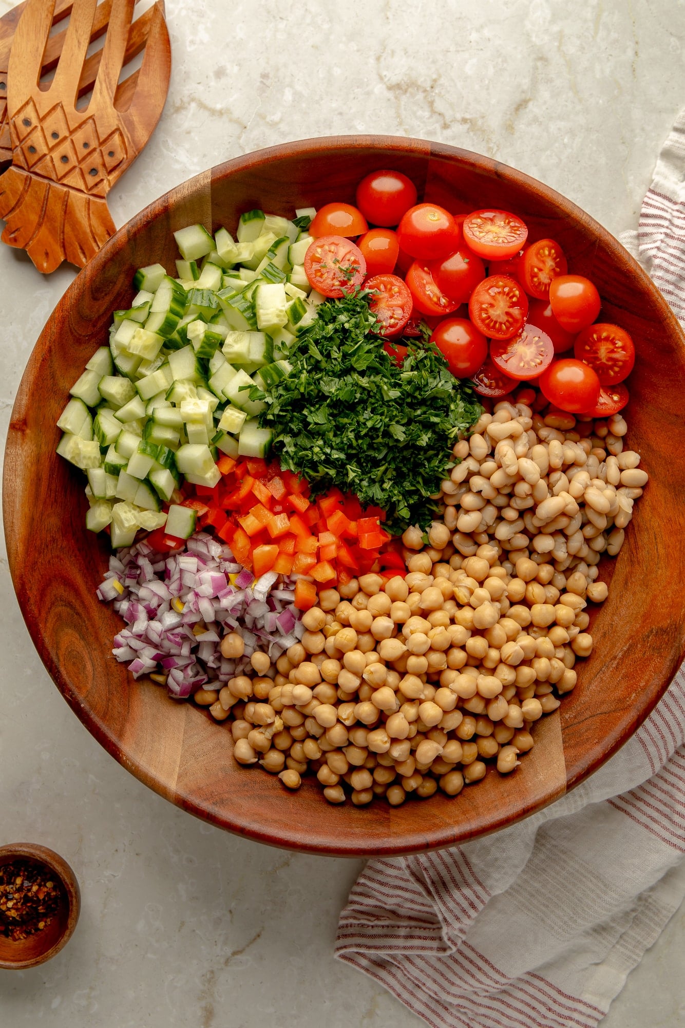 overhead view of the ingredients for a vegan dense bean salad in a large bamboo bowl.