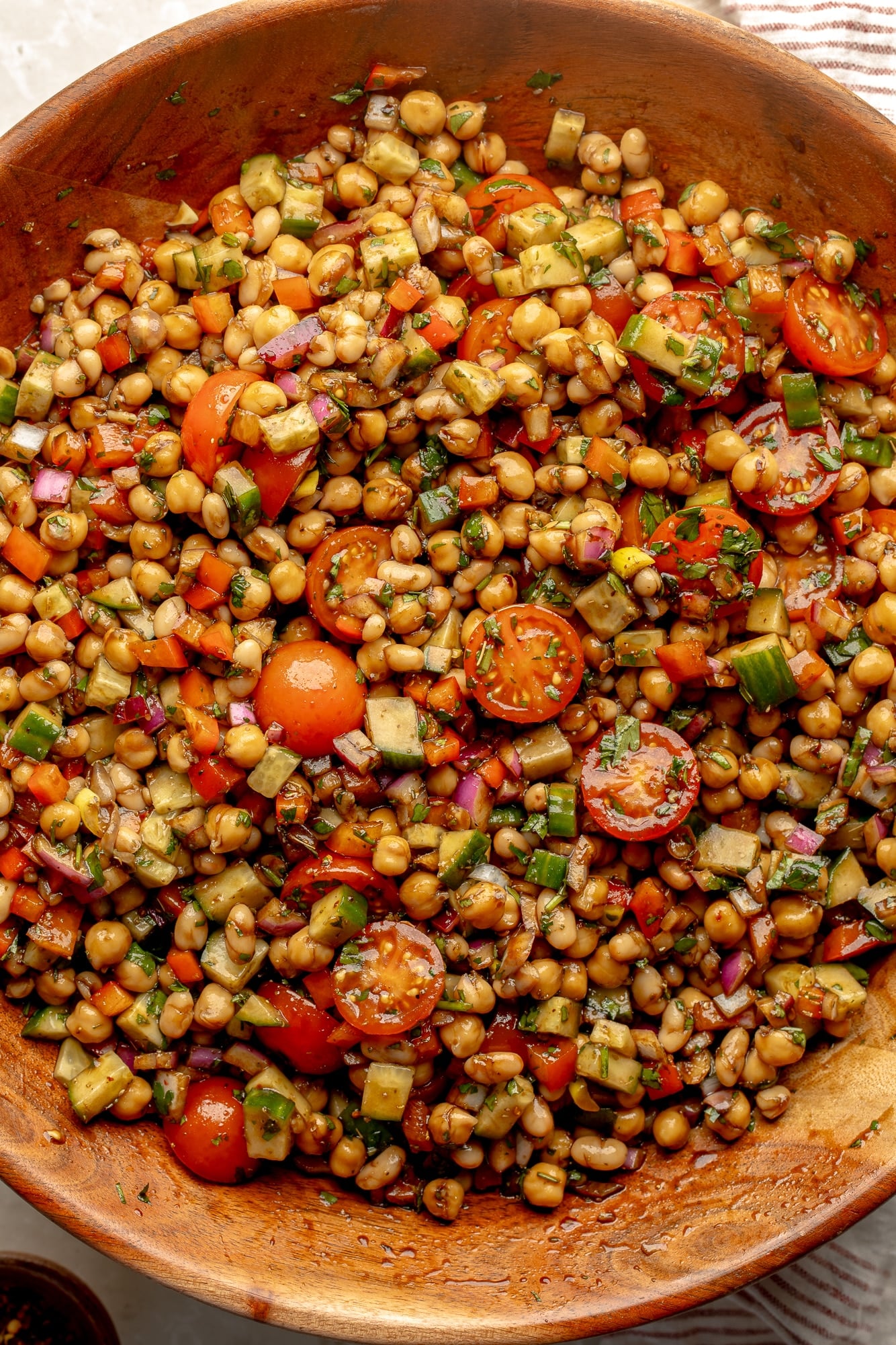overhead view of a dense bean salad in a large bamboo bowl.