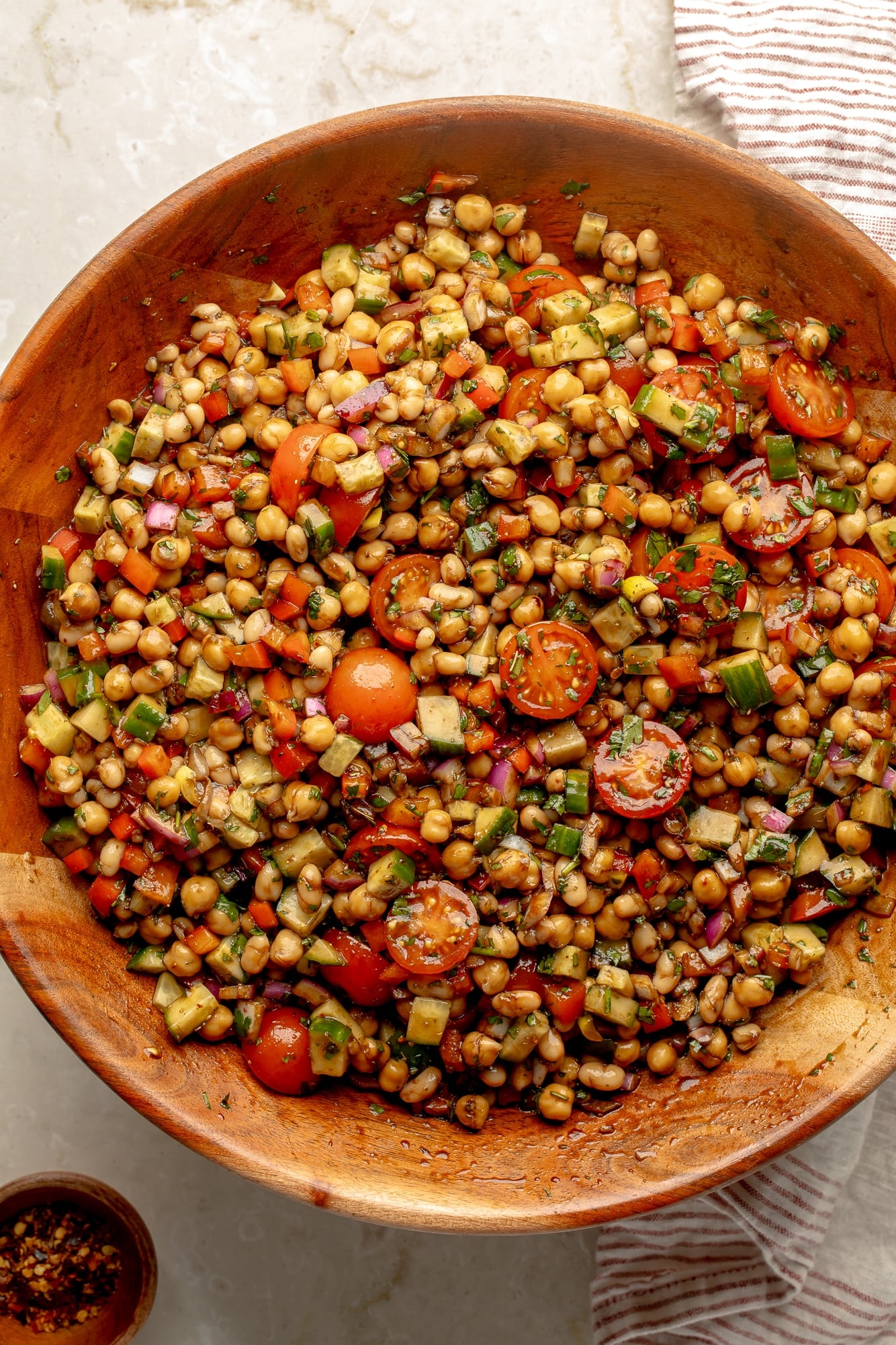 overhead view of a dense bean salad in a large bamboo bowl.