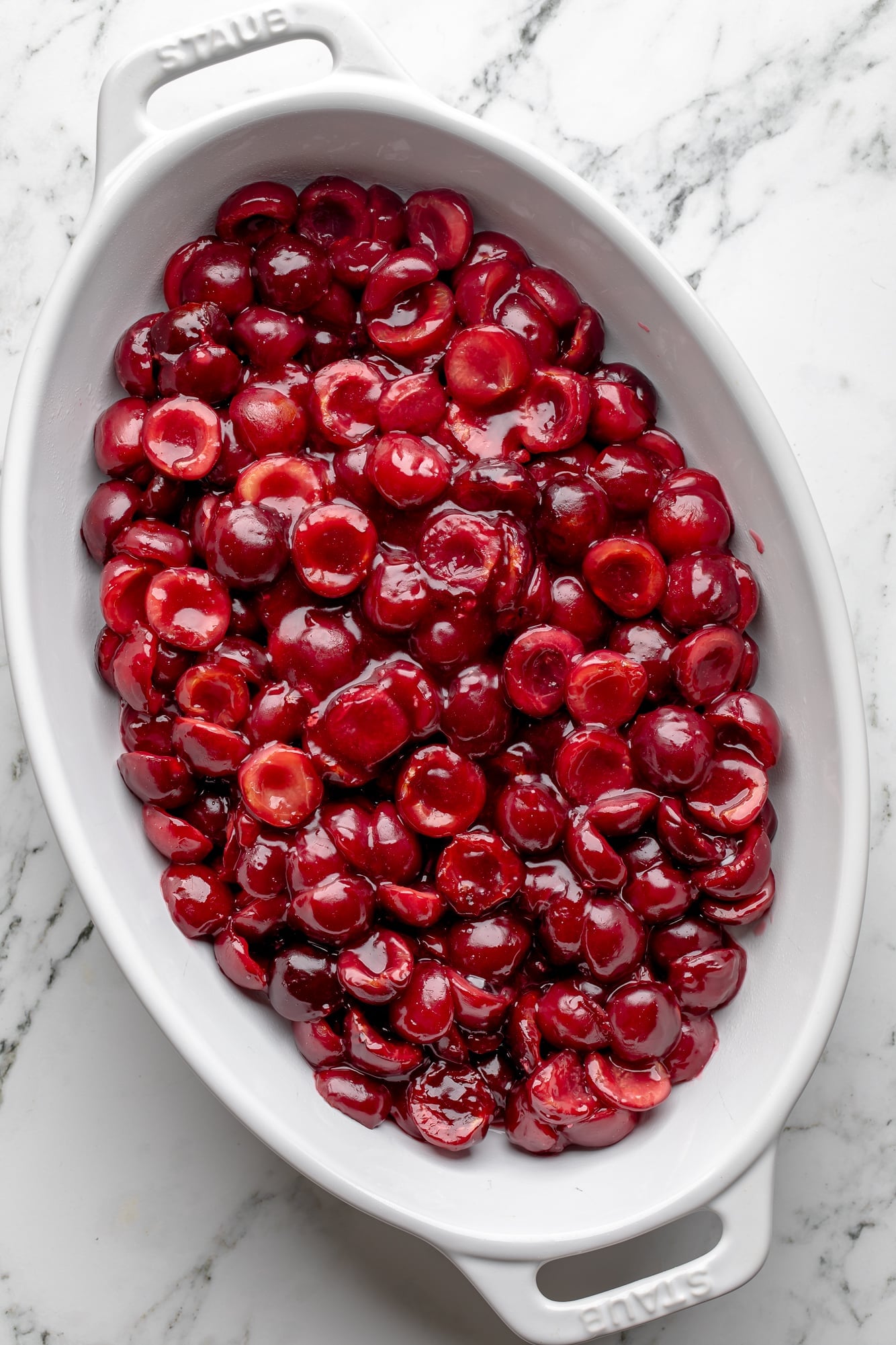 overhead view of the cherry filling for a vegan cherry cobbler in a large baking dish.