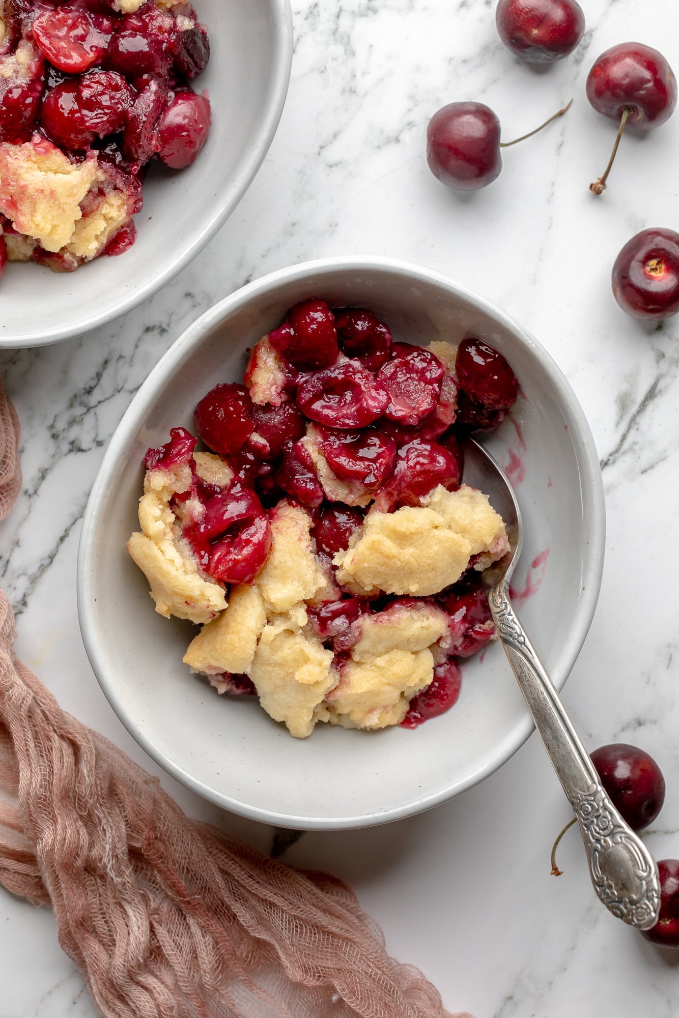 overhead view of a serving of vegan cherry cobbler in a bowl.