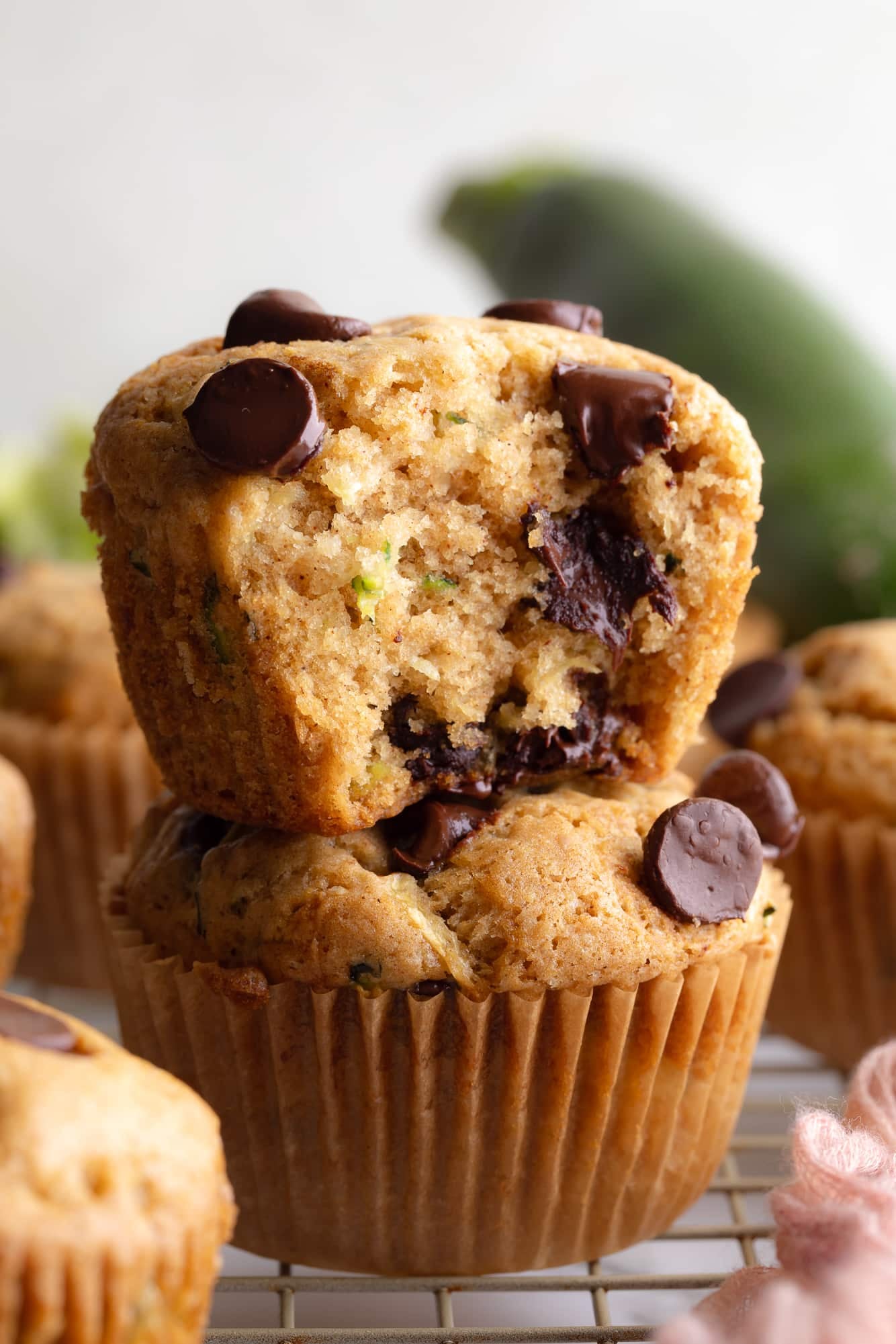side view of 2 vegan zucchini muffins stacked on top of each other.
