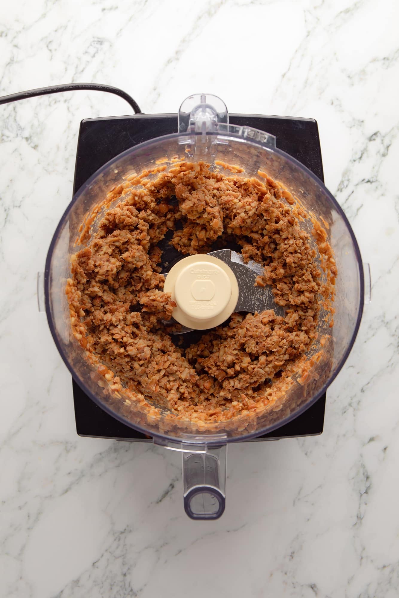 overhead view of mashed lentils for lentil burgers in a food processor.