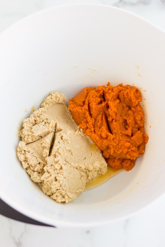 overhead view of the wet ingredients for vegan pumpkin cookie dough in a large white bowl.
