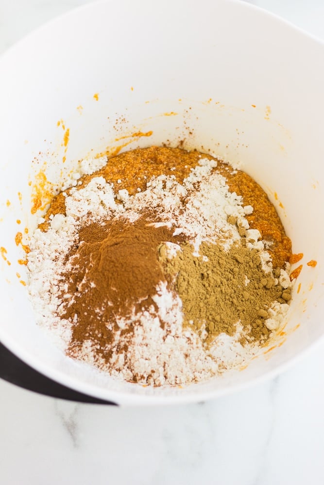 overhead view of the dry ingredients for vegan pumpkin cookie dough in a large white bowl.