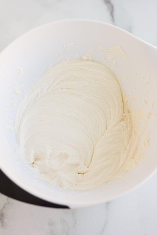 overhead view of white vegan frosting in a large white bowl.