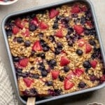 square image of baked berry oatmeal in a square baking pan.