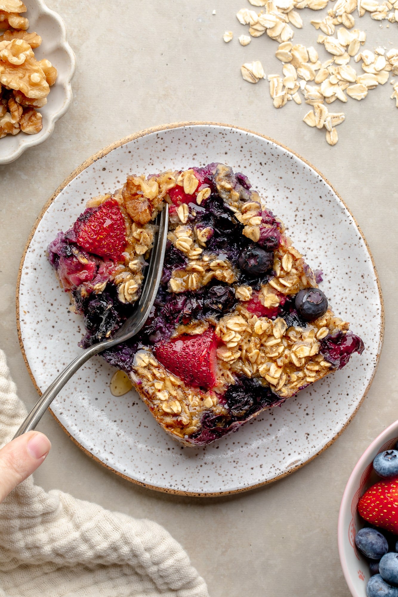 overhead view of a fork cutting into a slice of baked berry oatmeal.