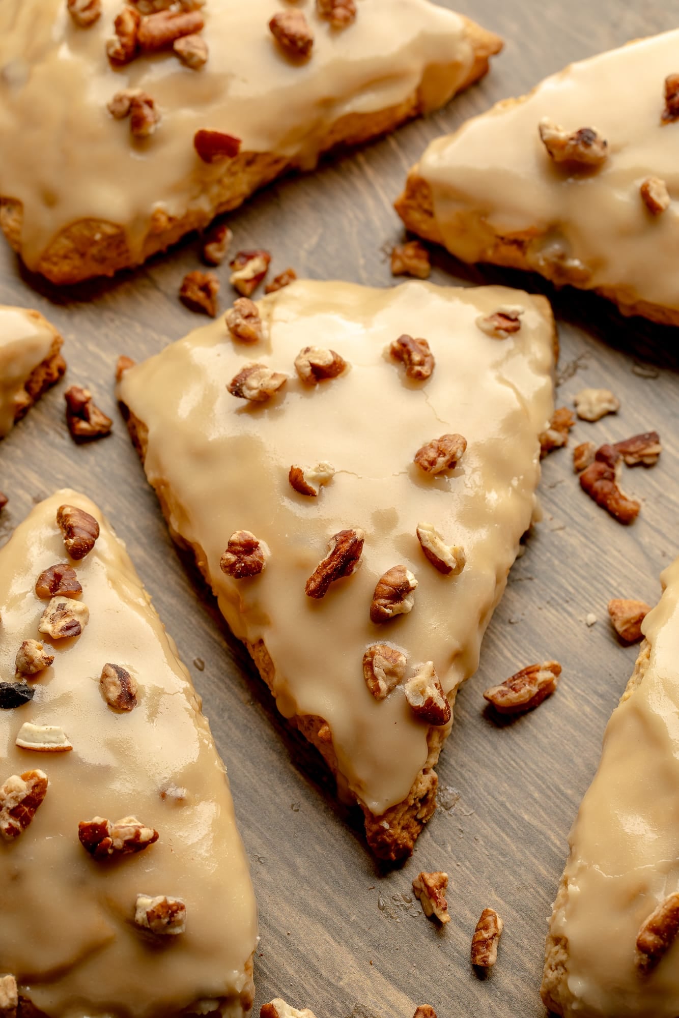 overhead view of vegan maple pecan scones topped with maple glaze and chopped pecans.