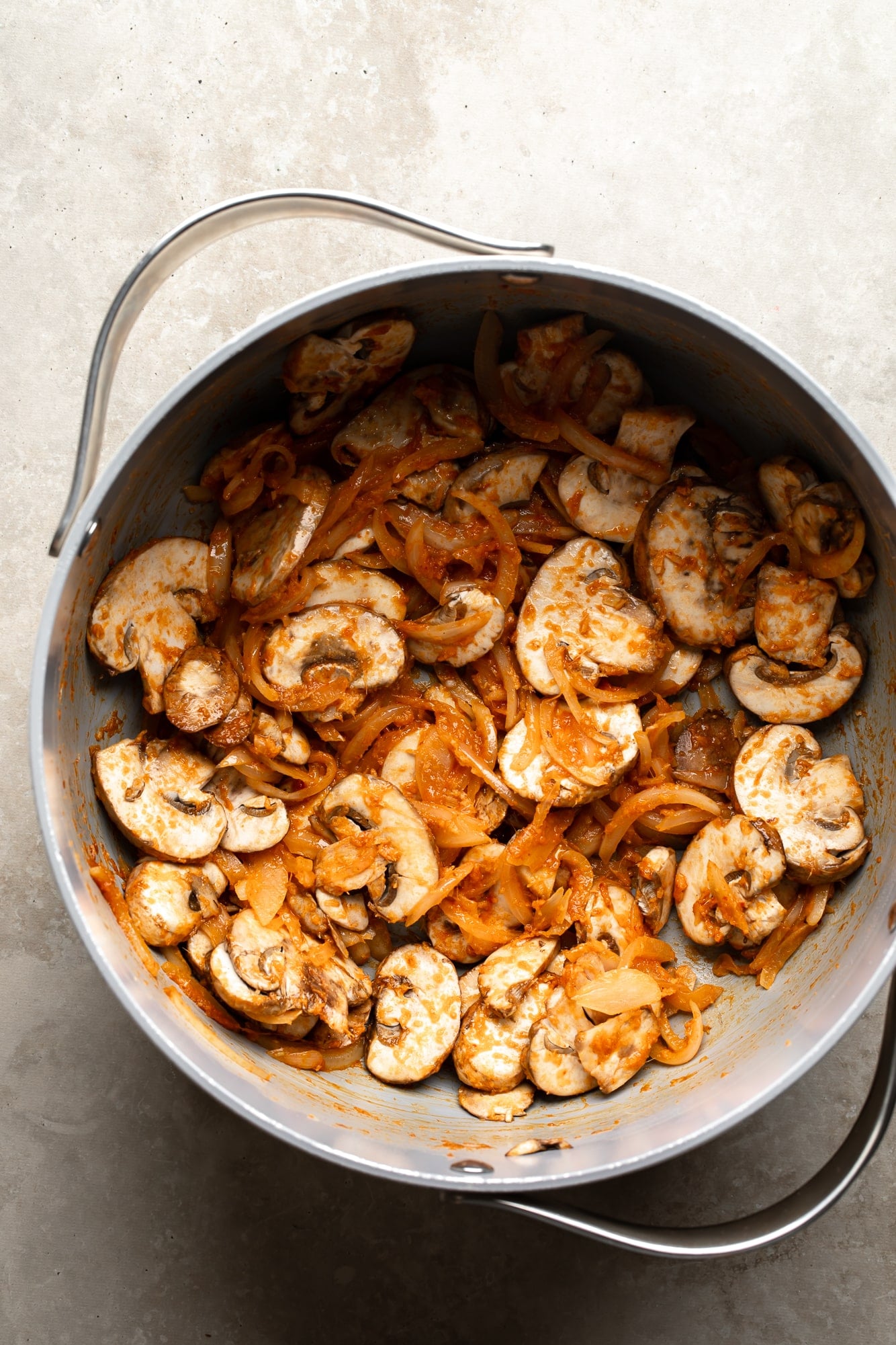 overhead view of aromatics and mushrooms cooking in a large pot for Thai Coconut Soup (Vegan Tom Kha).