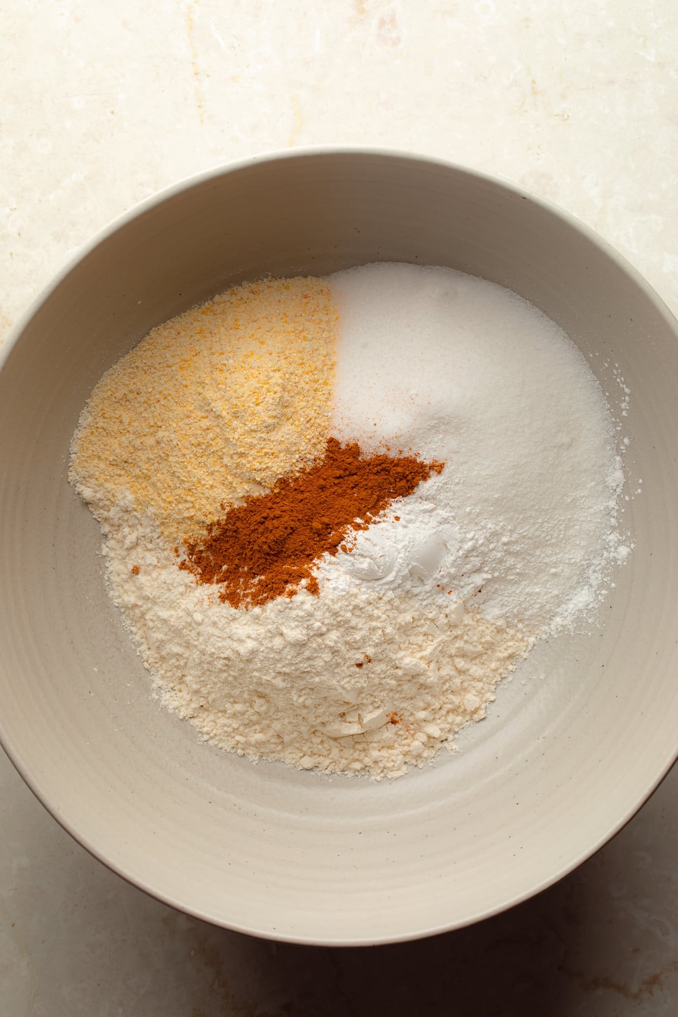 overhead view of the dry ingredients for vegan pumpkin cornbread in a bowl.