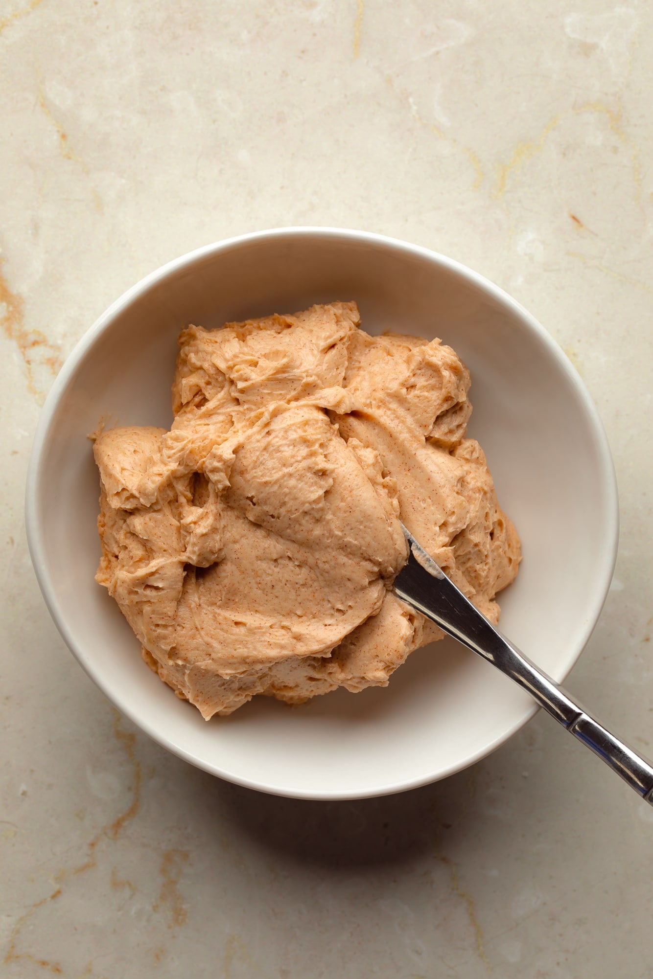 overhead view of whipped cinnamon maple butter for vegan pumpkin cornbread in a bowl.