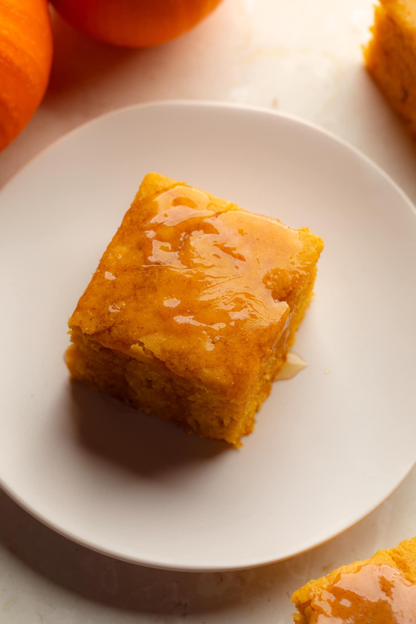 overhead view of a slice of vegan pumpkin cornbread on a plate.